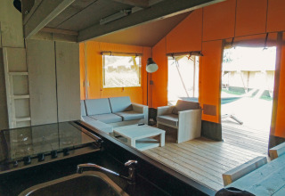 Vista interior de la tienda Safari cottage con muebles de madera en Holiday park De Boshoek, Países Bajos.