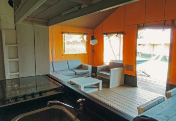 Vista interior de la tienda Safari cottage con muebles de madera en Holiday park De Boshoek, Países Bajos.