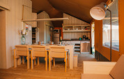 Interieur van een safaritent bij Vakantiepark De Boshoek in Nederland met keuken en eethoek.