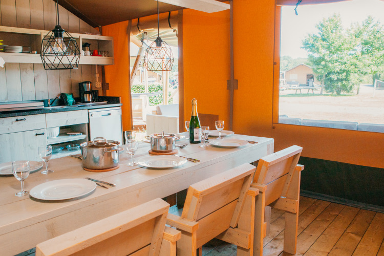 Interieur van Safari House op Vakantiepark De Boshoek, Nederland, met houten eettafel en keuken.