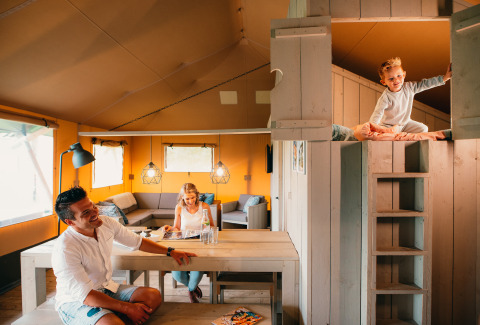 Gezin samen in een Safari House-tent bij vakantiepark De Boshoek in Nederland, sfeervol en gezellig interieur