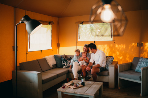 Familia relajándose en una tienda safari de lujo, Safari House, en Holiday park De Boshoek, Países Bajos.