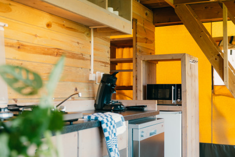 Moderne tekøkken i en luksussafari-lodge med træpaneler og mikrobølgeovn på Holiday park De Boshoek.