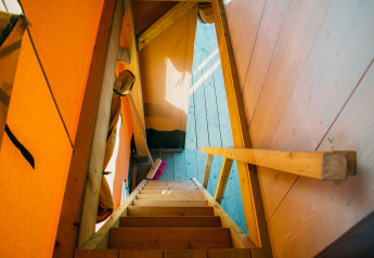 Wooden stairs inside a luxury safari lodge tent at Holiday park De Boshoek, Netherlands.