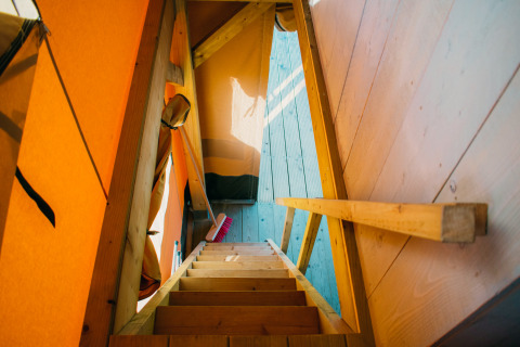 Houten trap in een luxe safaritent bij Holiday park De Boshoek, Nederland.