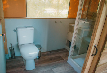 Modern bathroom in a luxury safari lodge at Holiday Park De Boshoek, Netherlands, with toilet and shower.