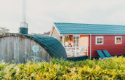 Veluwe lounge med sauna ved Holiday park De Boshoek i Holland, rød hytte og grønne omgivelser.