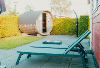 Zona de descanso al aire libre con dos tumbonas y una sauna barril en Holiday park De Boshoek, Países Bajos.