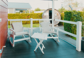 Veranda accogliente con sedie a dondolo e tavolo al Veluwe lounge + sauna, De Boshoek, Paesi Bassi.