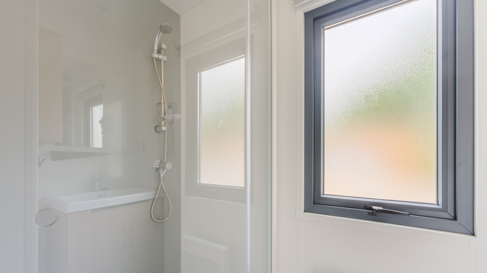 Moderne douche met matglasraam in Prestige Cottage op Camping Seasonova Haliotis, Frankrijk.