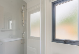 Moderne douche met matglasraam in Prestige Cottage op Camping Seasonova Haliotis, Frankrijk.