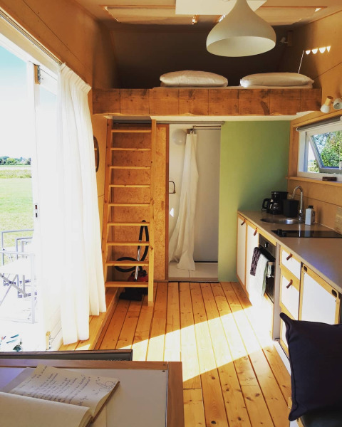 Knus lodge-interieur met slaapvide, keuken en douche bij Het Eilandhuis, 7Huizen aan Zee, Nederland.