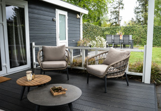 Udendørs loungeområde ved Heuvelrug Cottage på De Thijmse Berg med moderne møbler og grøn baghave.