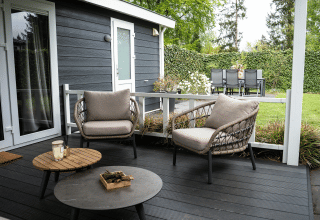 Buitenzitruimte bij Heuvelrug Cottage op De Thijmse Berg met moderne stoelen en tuinmeubilair in Nederland.