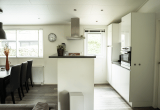 Modern kitchen and dining area inside Heuvelrug Cottage at De Thijmse Berg, Netherlands, bright and cozy.