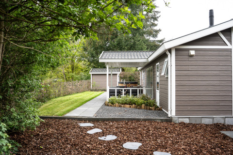 Wellness Cottage avec jacuzzi et sauna privés à De Thijmse Berg, Pays-Bas, entouré de verdure.