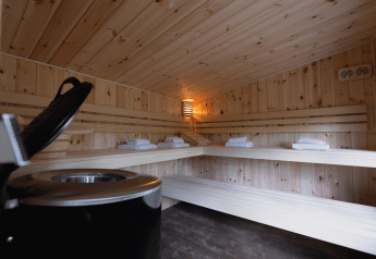 Interior de una sauna acogedora de madera con bancos y toallas en una cabaña de bienestar en el bosque.