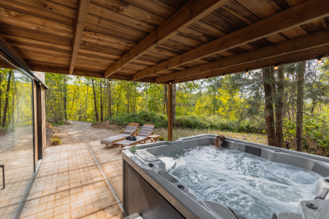 Vasca idromassaggio su terrazza coperta presso Comfort Sweet Wellness, Cosy Cabins nella foresta di Limburgo, Belgio.