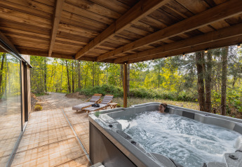 Vasca idromassaggio su terrazza coperta presso Comfort Sweet Wellness, Cosy Cabins nella foresta di Limburgo, Belgio.