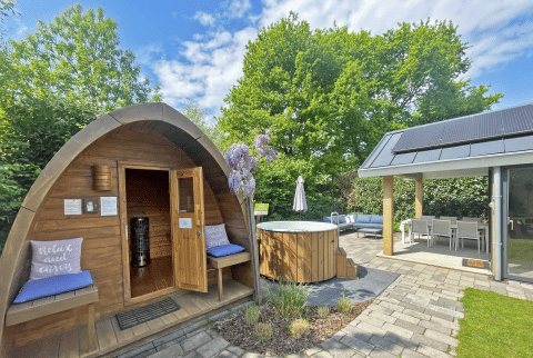 Udendørs wellnessområde ved Wellness Cottage i De Thijmse Berg, Holland, med sauna, badetønde og terrasse.