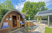 Udendørs wellnessområde ved Wellness Cottage i De Thijmse Berg, Holland, med sauna, badetønde og terrasse.