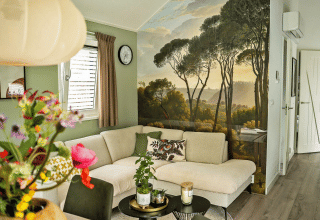 Sala moderna en Wellness Cottage de De Thijmse Berg con mural de bosque y cómodo sofá claro en la esquina.