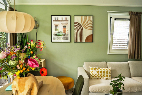 Sala moderna en Wellness Cottage, De Thijmse Berg, Países Bajos, con arte llamativo y decoración floral.