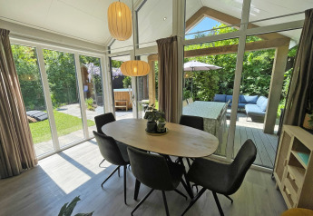 Lyst opholdsområde i Wellness Cottage på De Thijmse Berg, Holland, med udsigt til terrasse og have.