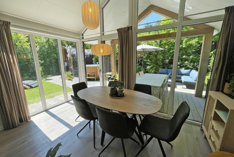 Salle à manger lumineuse au Wellness Cottage, De Thijmse Berg, Pays-Bas, ouvrant sur terrasse et jardin.
