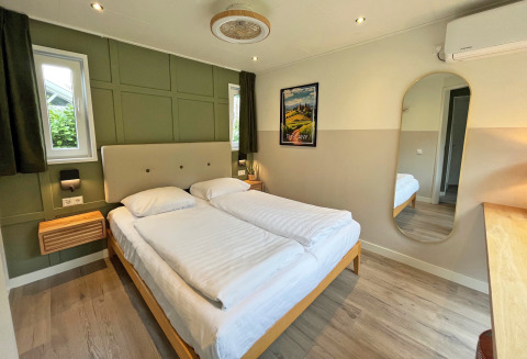 Dormitorio en Wellness Cottage en De Thijmse Berg, Países Bajos, con decoración moderna y cama doble.