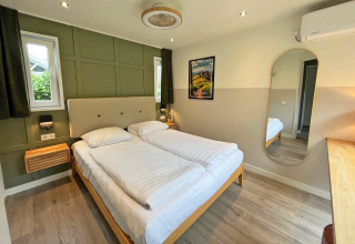 Dormitorio en Wellness Cottage en De Thijmse Berg, Países Bajos, con decoración moderna y cama doble.