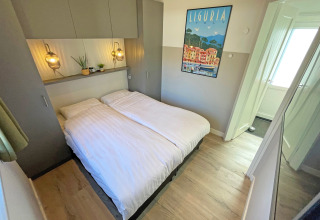 Cabaña Wellness en De Thijmse Berg, Países Bajos, dormitorio moderno con cama doble y decoración luminosa.
