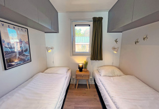Dormitorio con dos camas individuales y decoración moderna en Wellness Cottage, De Thijmse Berg, Países Bajos.