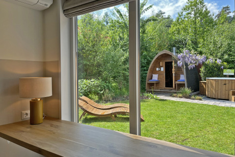 Vista desde Wellness Cottage en De Thijmse Berg, Países Bajos, con jardín, sauna y silla de descanso al aire libre.