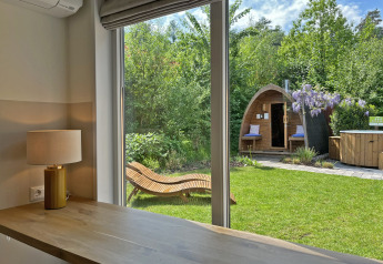Udsigt fra Wellness Cottage ved De Thijmse Berg i Holland, med have, sauna og afslapningsbænk udenfor.