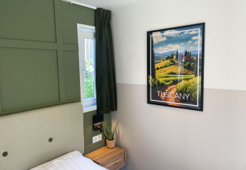 Moderne slaapkamer in Wellness Cottage bij De Thijmse Berg met Toscane-poster en groene accenten.