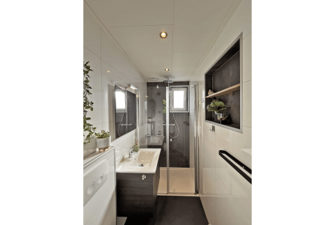 Moderne badkamer in Wellness Cottage bij De Thijmse Berg, Nederland, met glazen douche en planten.