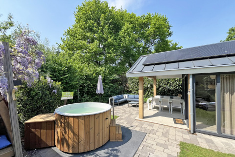 Wellness Cottage en De Thijmse Berg, Países Bajos, con jacuzzi, terraza y zona de estar al aire libre.