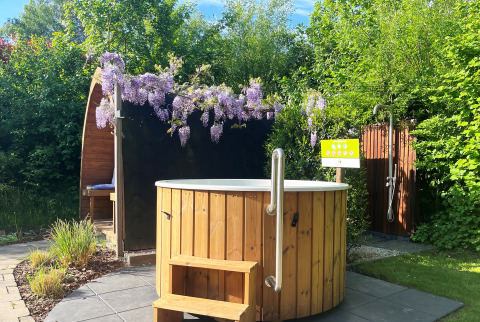 Udendørs wellnessområde i Wellness Cottage på De Thijmse Berg, med vildmarksbad, bruser og grønne omgivelser.
