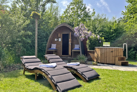 Zona de bienestar al aire libre en Wellness Cottage, De Thijmse Berg, Países Bajos con sauna y tumbonas.