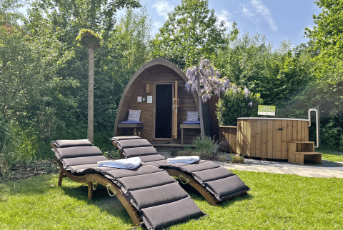 Buiten wellnessruimte bij Wellness Cottage, De Thijmse Berg, Nederland met sauna en ligstoelen.
