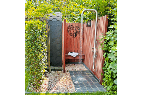 Udendørs bruser ved Wellness Cottage, De Thijmse Berg, Holland, omgivet af grønt og trævægge.