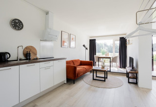 Innenaufnahme von Tiny House XL bei The Kremmer in den Niederlanden mit moderner Küche und Wohnzimmer.