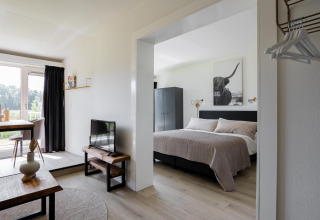 Vista interior de Tiny House XL en The Kremmer, Países Bajos, con dormitorio, salón y zona de comedor.