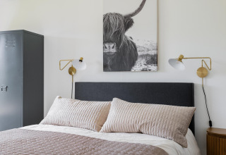 Schlafzimmer im Tiny House XL bei The Kremmer, Niederlande, mit moderner Dekoration und Wandkunst.