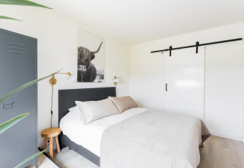 Lyst og moderne soveværelse i Tiny House XL ved The Kremmer, Holland, med minimalistisk indretning.