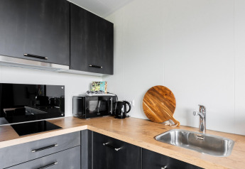 Cucina moderna nella Tiny House with decking at The Kremmer nei Paesi Bassi con piano in legno e elettrodomestici.