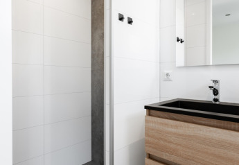 Moderne badeværelse i tiny house på The Kremmer, Holland, med trævask og minimalistisk bruseniche.