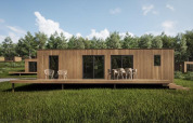 Moderne houten lodge met terras en tuinstoelen bij Eco Lodge, Hameau de l'Ourthe, België, in het groen.