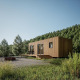 Modern wooden Eco Lodge with a deck, set amidst lush greenery and surrounded by a scenic forest.